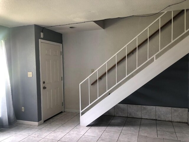 17230 Imperial Valley Dr Unit 24, Houston, TX 77060 - entryway featuring tile patterned floors, a textured ceiling, and stairway