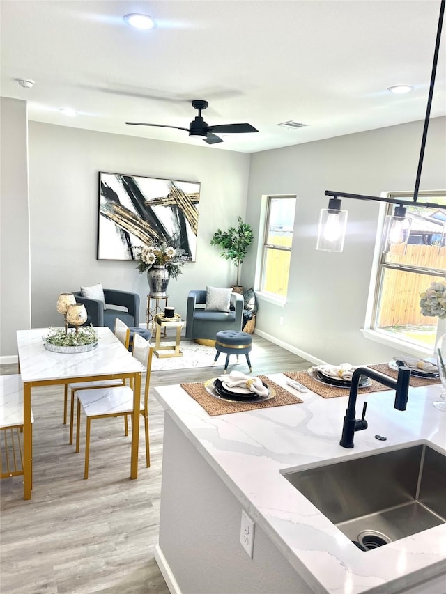 863 Dolly Wright St, Houston, TX 77088 - kitchen featuring a sink, light wood-type flooring, light stone countertops, baseboards, and recessed lighting