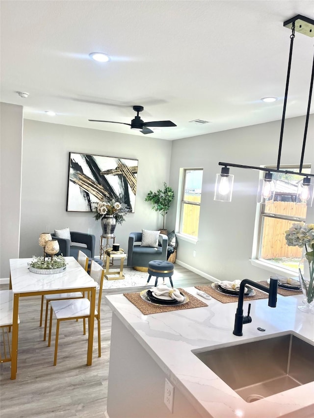 863 Dolly Wright St, Houston, TX 77088 - kitchen featuring a sink, light wood-type flooring, baseboards, light stone counters, and recessed lighting