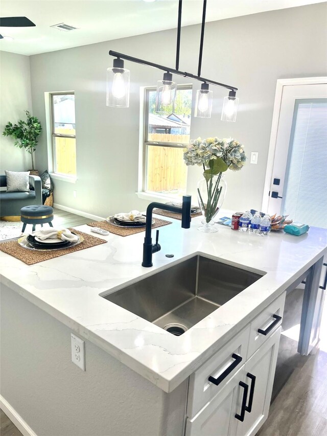863 Dolly Wright St, Houston, TX 77088 - kitchen featuring a sink, dark wood finished floors, light stone countertops, and white cabinetry