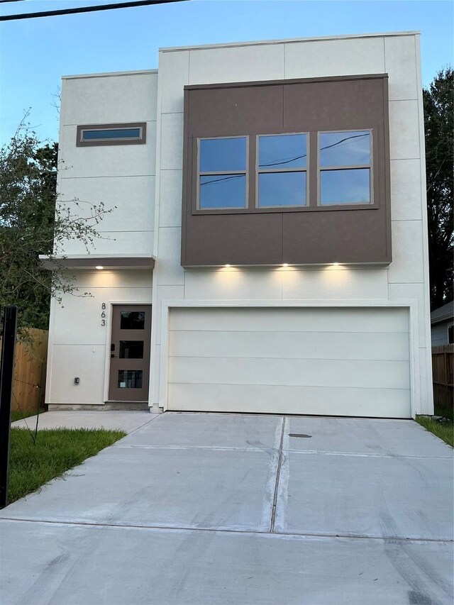 863 Dolly Wright St, Houston, TX 77088 - contemporary house featuring an attached garage, concrete driveway, and stucco siding