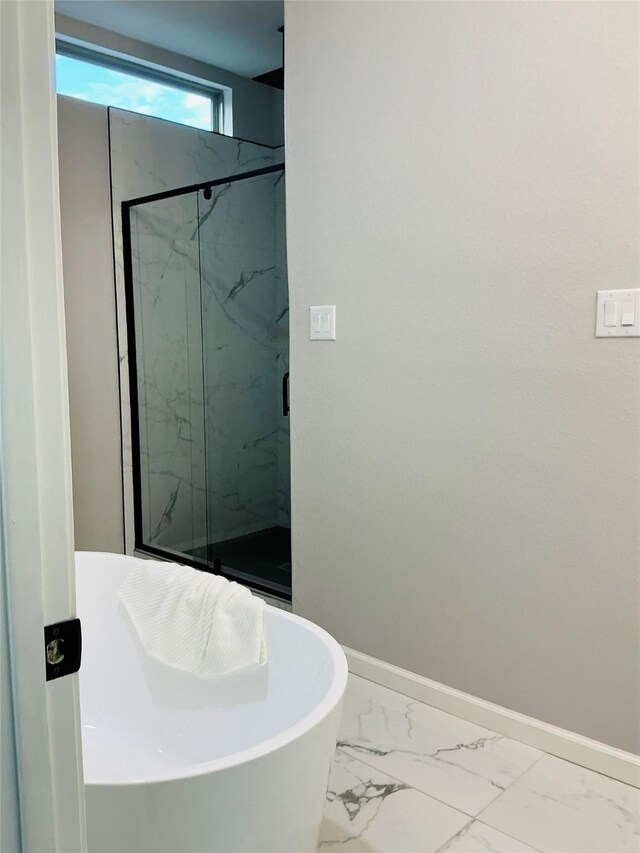 863 Dolly Wright St, Houston, TX 77088 - bathroom featuring marble look tile flooring, a marble finish shower, baseboards, and a soaking tub