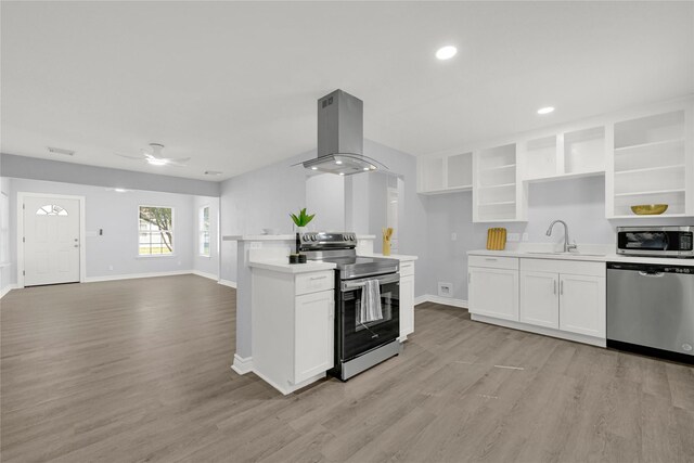 11423 Raincove Dr, Houston, TX 77016 - kitchen with stainless steel appliances, island exhaust hood, a sink, baseboards, and light countertops