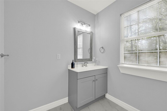 11423 Raincove Dr, Houston, TX 77016 - bathroom with vanity, baseboards, and marble finish flooring