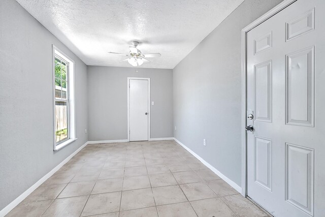 11423 Raincove Dr, Houston, TX 77016 - unfurnished room with ceiling fan, a textured ceiling, baseboards, and light tile patterned floors