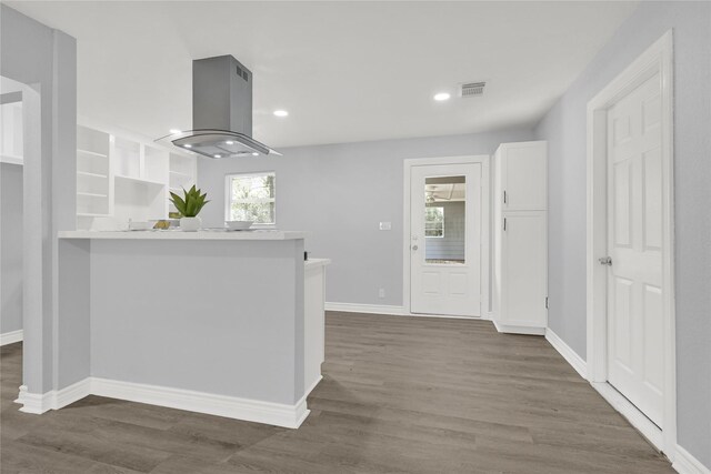 11423 Raincove Dr, Houston, TX 77016 - kitchen featuring baseboards, island exhaust hood, dark wood finished floors, white cabinetry, and recessed lighting