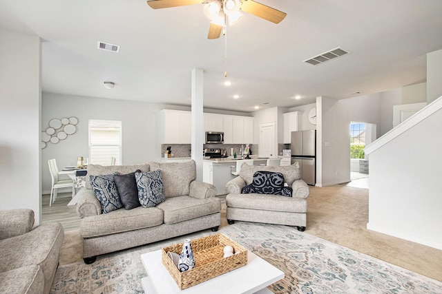 40557 Mostyn Lake Dr, Magnolia, TX 77354 - living room with healthy amount of natural light, a ceiling fan, baseboards, recessed lighting, and light colored carpet