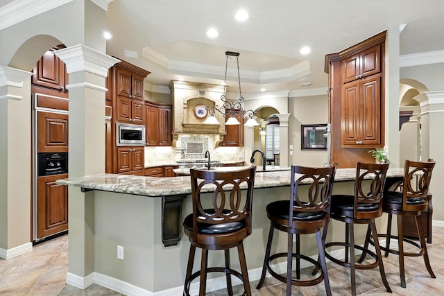 4503 Summits Edge Ln, Katy, TX 77494 - kitchen with stainless steel microwave, ornate columns, arched walkways, a peninsula, and crown molding