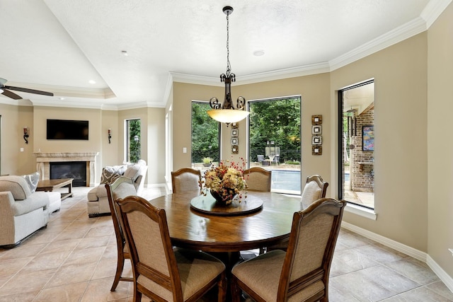 4503 Summits Edge Ln, Katy, TX 77494 - dining area featuring light tile patterned floors, a ceiling fan, a glass covered fireplace, and ornamental molding