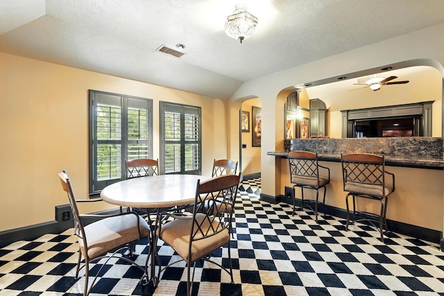 4503 Summits Edge Ln, Katy, TX 77494 - dining space with arched walkways, lofted ceiling, a textured ceiling, tile patterned floors, and a ceiling fan