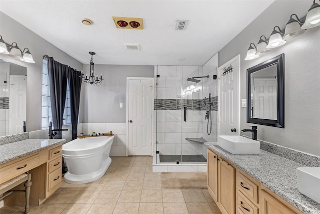 5810 Dixie Ln, Baytown, TX 77523 - full bath with a stall shower, a freestanding tub, double vanity, tile patterned floors, and a chandelier
