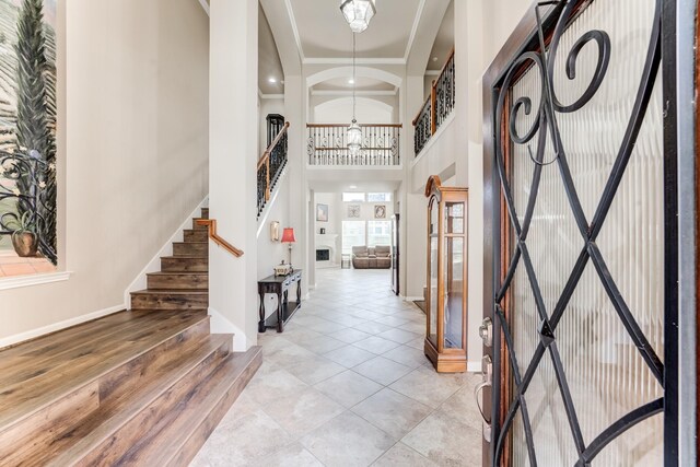 2215 Dali Ln, Missouri City, TX 77459 - foyer with a high ceiling, a chandelier, baseboards, stairway, and light tile patterned floors