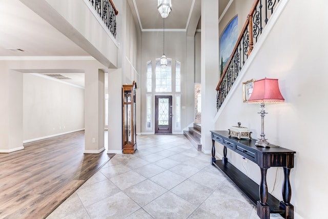 2215 Dali Ln, Missouri City, TX 77459 - entryway with crown molding, a high ceiling, stairs, baseboards, and wood finished floors