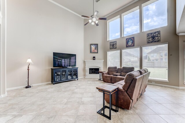 2215 Dali Ln, Missouri City, TX 77459 - living room with a high ceiling, light tile patterned floors, ornamental molding, a ceiling fan, and baseboards