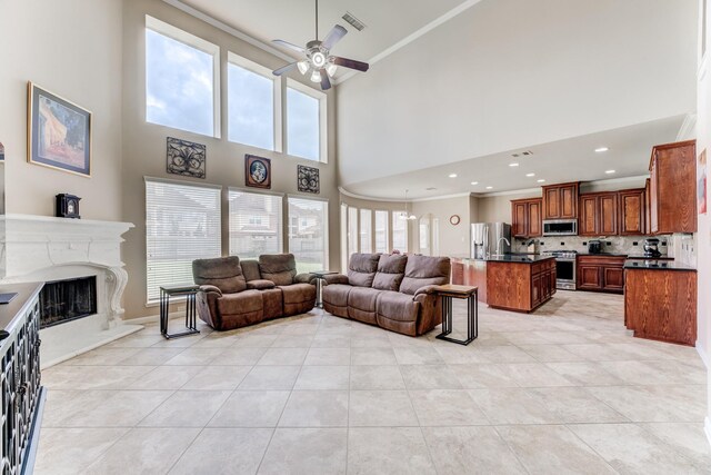 2215 Dali Ln, Missouri City, TX 77459 - living area with a ceiling fan, light tile patterned floors, a premium fireplace, a high ceiling, and crown molding