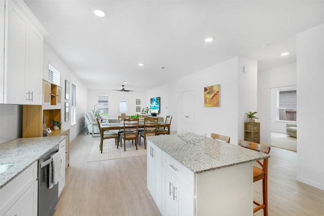 16910 Elm Grove Rd, Conroe, TX 77302 - kitchen with dishwasher, a kitchen breakfast bar, light wood-style floors, a center island, and recessed lighting