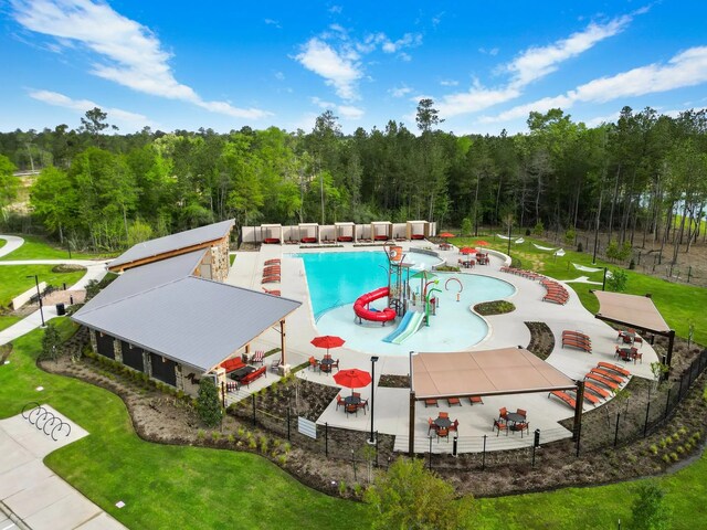 16910 Elm Grove Rd, Conroe, TX 77302 - community pool with a patio area, a forest view, and a water play area