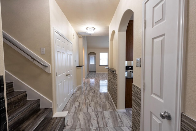 6442 Wilshire Lks, Houston, TX 77040 - corridor featuring arched walkways, marble look tiles, and stairs