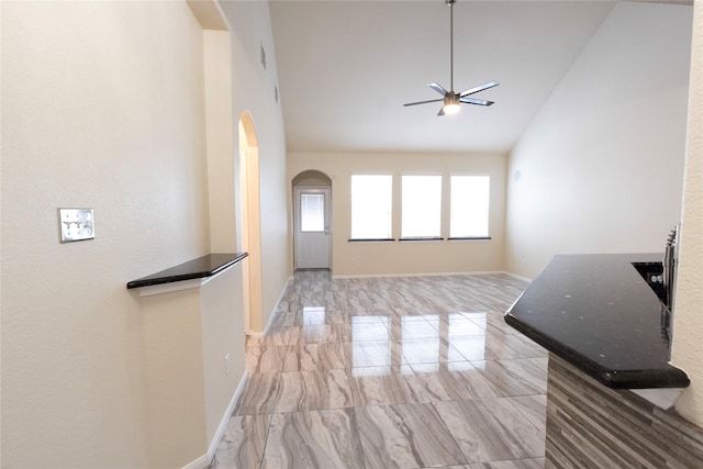 6442 Wilshire Lks, Houston, TX 77040 - unfurnished living room with arched walkways, ceiling fan, light marble finish flooring, and high vaulted ceiling