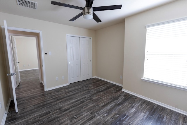 6442 Wilshire Lks, Houston, TX 77040 - unfurnished bedroom featuring dark wood-type flooring, a closet, multiple windows, and a ceiling fan