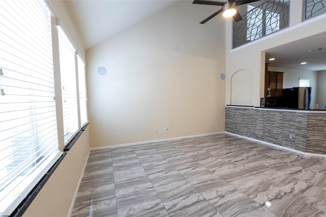 6442 Wilshire Lks, Houston, TX 77040 - unfurnished living room with healthy amount of natural light, high vaulted ceiling, ceiling fan, and light marble finish floors