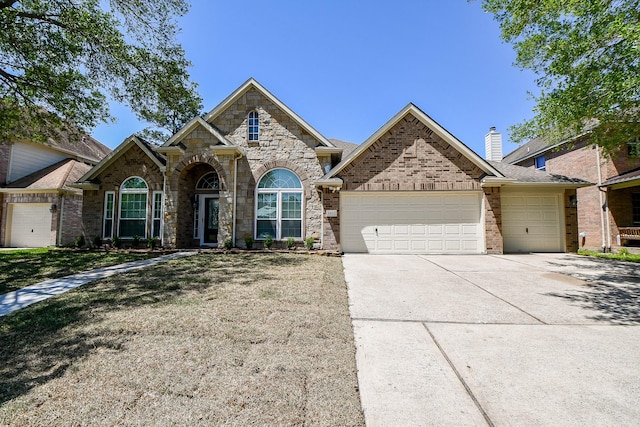6402 Amelia Springs Dr, Spring, TX 77379 - view of front of home featuring an attached garage, driveway, stone siding, a front lawn, and brick siding