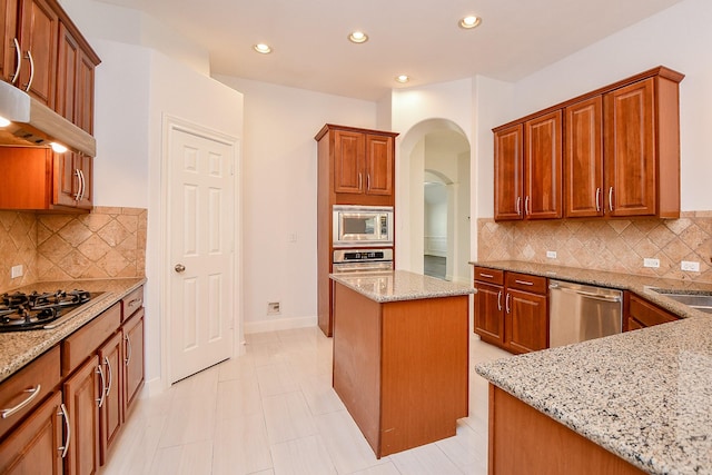 6402 Amelia Springs Dr, Spring, TX 77379 - kitchen featuring stainless steel appliances, light stone countertops, arched walkways, extractor fan, and recessed lighting