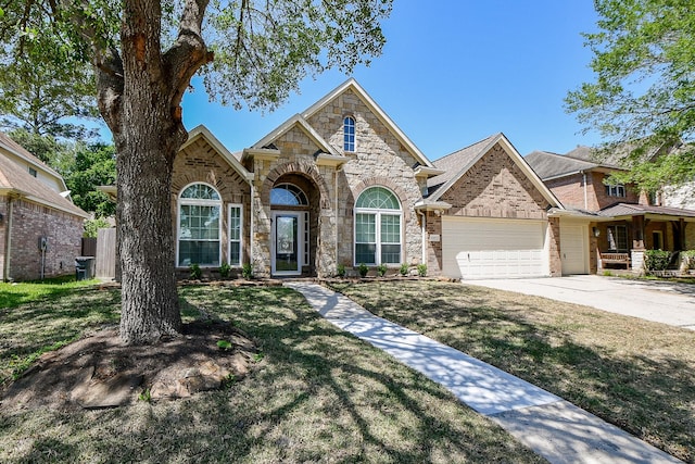 6402 Amelia Springs Dr, Spring, TX 77379 - view of front of home with a garage, a front lawn, stone siding, concrete driveway, and brick siding