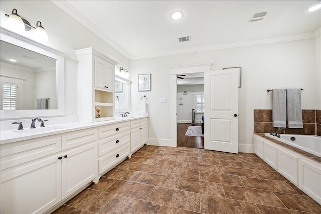 1136 Nadine St, Houston, TX 77009 - bathroom featuring ornamental molding, double vanity, a garden tub, baseboards, and stone finish flooring