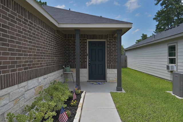 1887 Brushy Cedar Dr, Conroe, TX 77301 - entrance to property featuring central air condition unit, a lawn, brick siding, and cooling unit