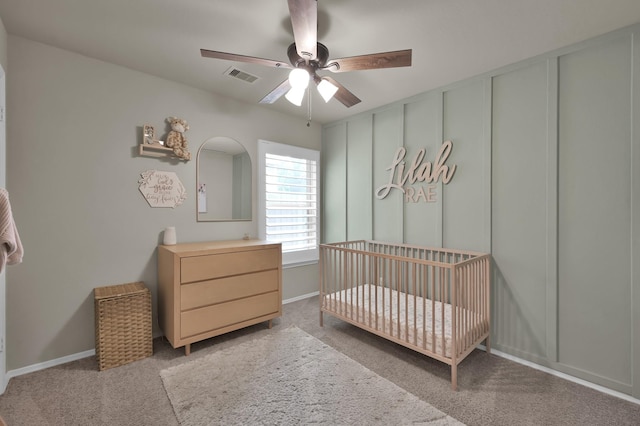 1887 Brushy Cedar Dr, Conroe, TX 77301 - bedroom featuring carpet floors, a crib, a ceiling fan, baseboards, and a decorative wall