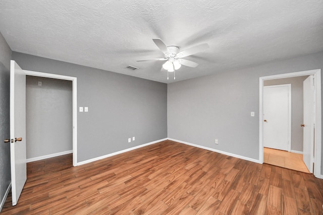 9422 Val Verde St, Houston, TX 77063 - unfurnished bedroom featuring wood finished floors, baseboards, ceiling fan, and a textured ceiling