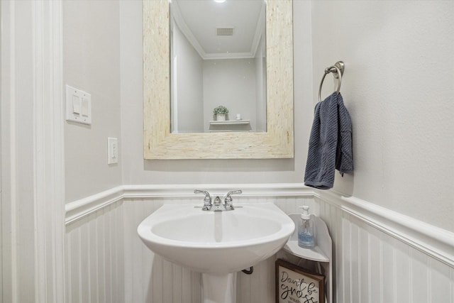 818 Garden Rose Ln, Houston, TX 77018 - bathroom featuring wainscoting, a decorative wall, and ornamental molding