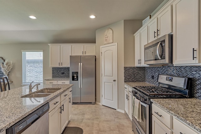 13919 Leigh Lake Ln, Conroe, TX 77384 - kitchen with stainless steel appliances, white cabinetry, decorative backsplash, light stone counters, and recessed lighting