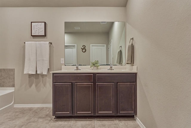 13919 Leigh Lake Ln, Conroe, TX 77384 - bathroom featuring double vanity, a garden tub, tile patterned flooring, and a textured wall
