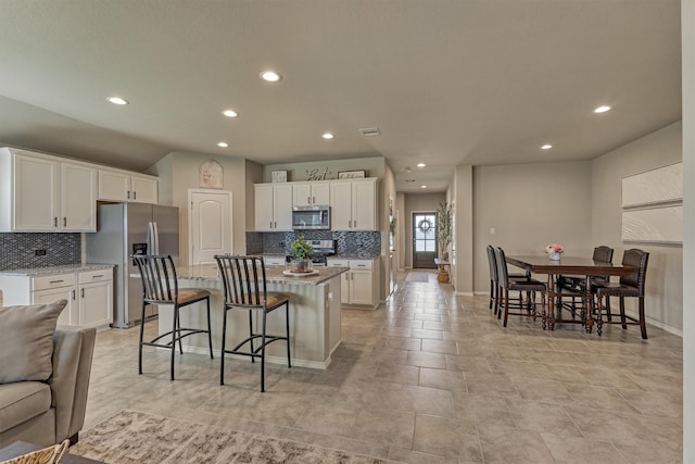 13919 Leigh Lake Ln, Conroe, TX 77384 - kitchen with stainless steel appliances, backsplash, recessed lighting, a center island, and white cabinetry