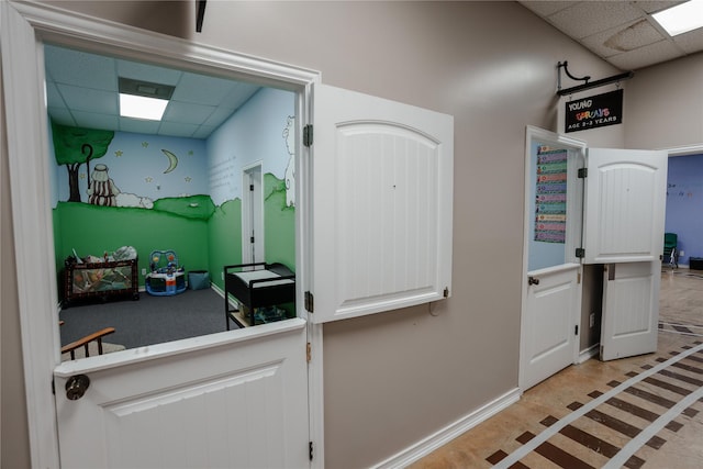 2027 Fm 1942nd Rd, Crosby, TX 77532 - kitchen featuring a drop ceiling, baseboards, white cabinetry, and inlaid floor details
