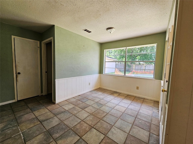 16438 Glenshannon Dr, Houston, TX 77059 - empty room with a textured ceiling and a wainscoted wall