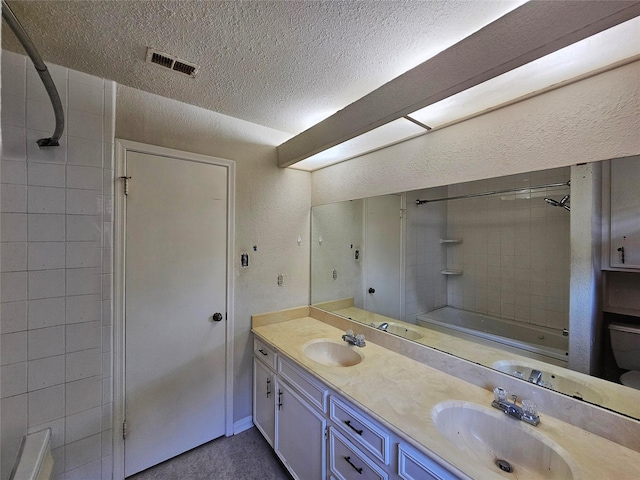 16438 Glenshannon Dr, Houston, TX 77059 - bathroom featuring a textured ceiling, double vanity, a textured wall, and bathing tub / shower combination