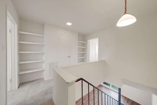 215 Postoffice St Unit 702, Galveston, TX 77550 - hallway featuring an upstairs landing, built in features, and light colored carpet