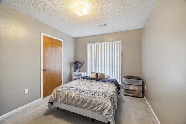 1105 Mesquite St, Baytown, TX 77521 - carpeted bedroom featuring a textured ceiling and baseboards