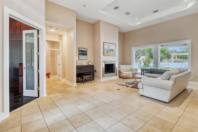 51 Wincrest Falls Dr, Cypress, TX 77429 - living room featuring light tile patterned floors, a tray ceiling, a fireplace, recessed lighting, and a high ceiling