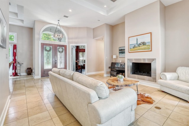 51 Wincrest Falls Dr, Cypress, TX 77429 - living room with light tile patterned floors, a towering ceiling, a fireplace, recessed lighting, and a chandelier