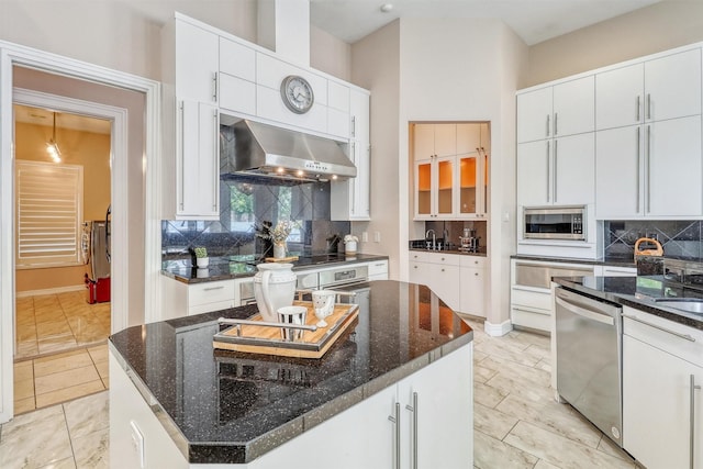 51 Wincrest Falls Dr, Cypress, TX 77429 - kitchen featuring stainless steel appliances, ventilation hood, backsplash, and dark stone counters