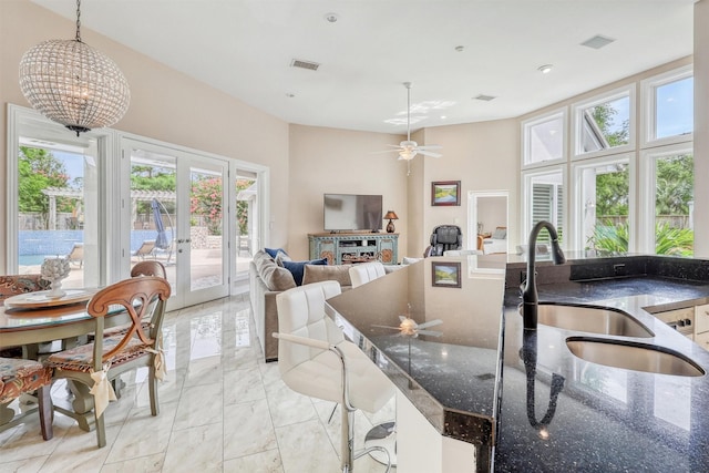 51 Wincrest Falls Dr, Cypress, TX 77429 - kitchen featuring light marble finish flooring, french doors, plenty of natural light, ceiling fan, and a towering ceiling