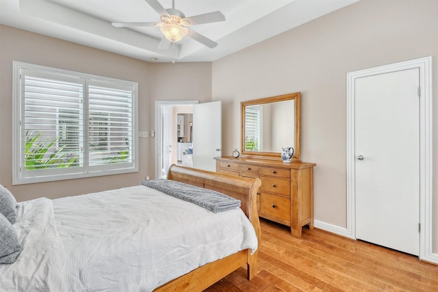 51 Wincrest Falls Dr, Cypress, TX 77429 - bedroom with light wood-style flooring, multiple windows, ceiling fan, and a tray ceiling