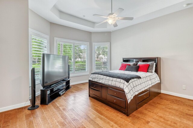 51 Wincrest Falls Dr, Cypress, TX 77429 - bedroom with light wood-style floors, a raised ceiling, and ceiling fan