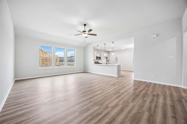520 Barton Place Dr, Cleveland, TX 77327 - unfurnished living room with ceiling fan, wood finished floors, and baseboards