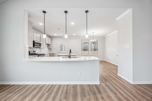 520 Barton Place Dr, Cleveland, TX 77327 - kitchen with stainless steel appliances, a sink, light countertops, baseboards, and light wood-style flooring