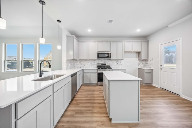 520 Barton Place Dr, Cleveland, TX 77327 - kitchen with stainless steel appliances, a sink, tasteful backsplash, light wood finished floors, and recessed lighting